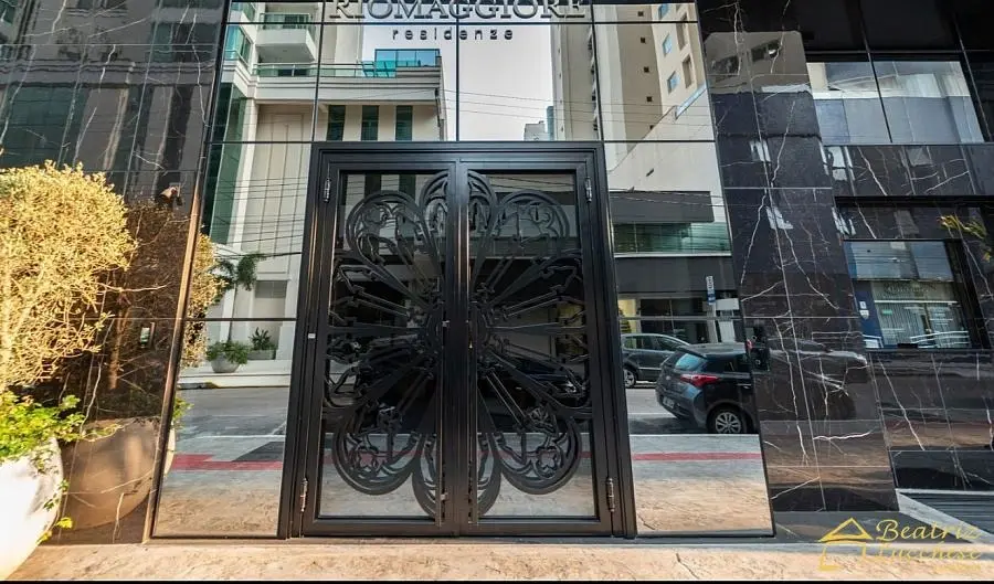 Entrada exclusiva do Riomaggiore Residenze - Fachada em mármore negro com portas em ferro trabalhado, bairro Pioneiros, Balneário Camboriú